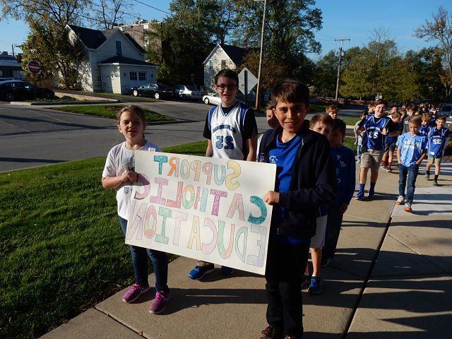 Group of St Pets students walking and holding a Support Catholic Education sign
